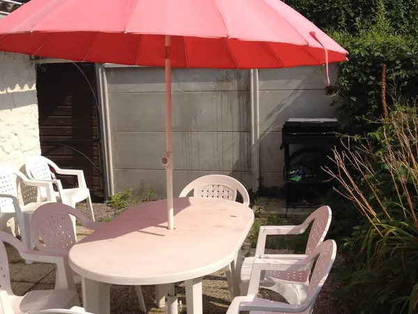 La terrasse avec salon de jardin et parasol